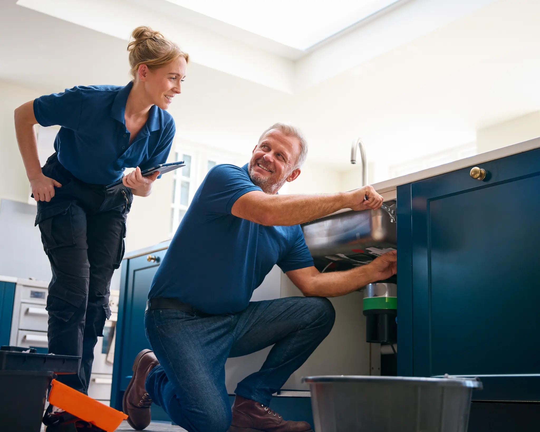 Plumber and trainee working on sink