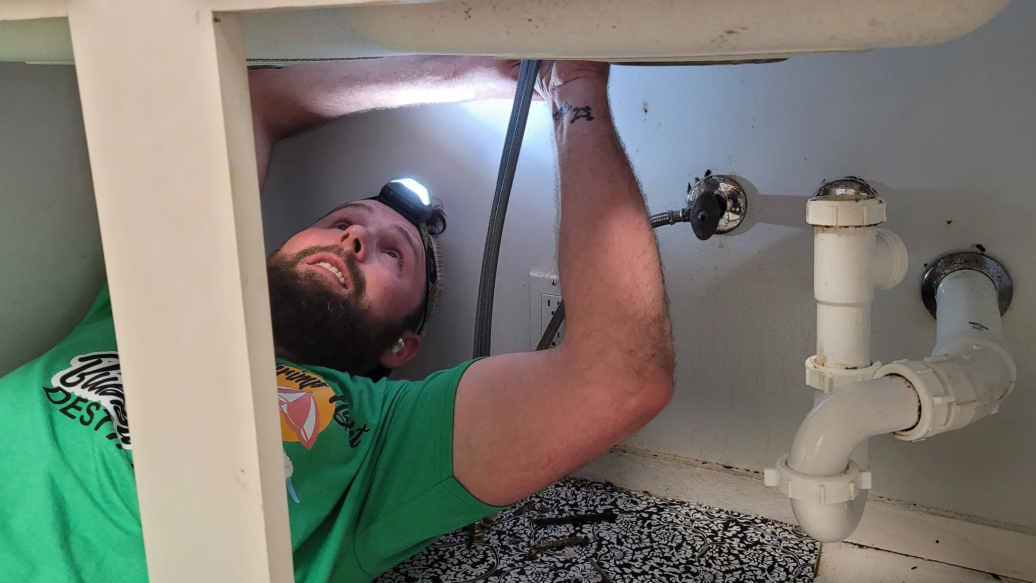 Plumber installing under sink pipes