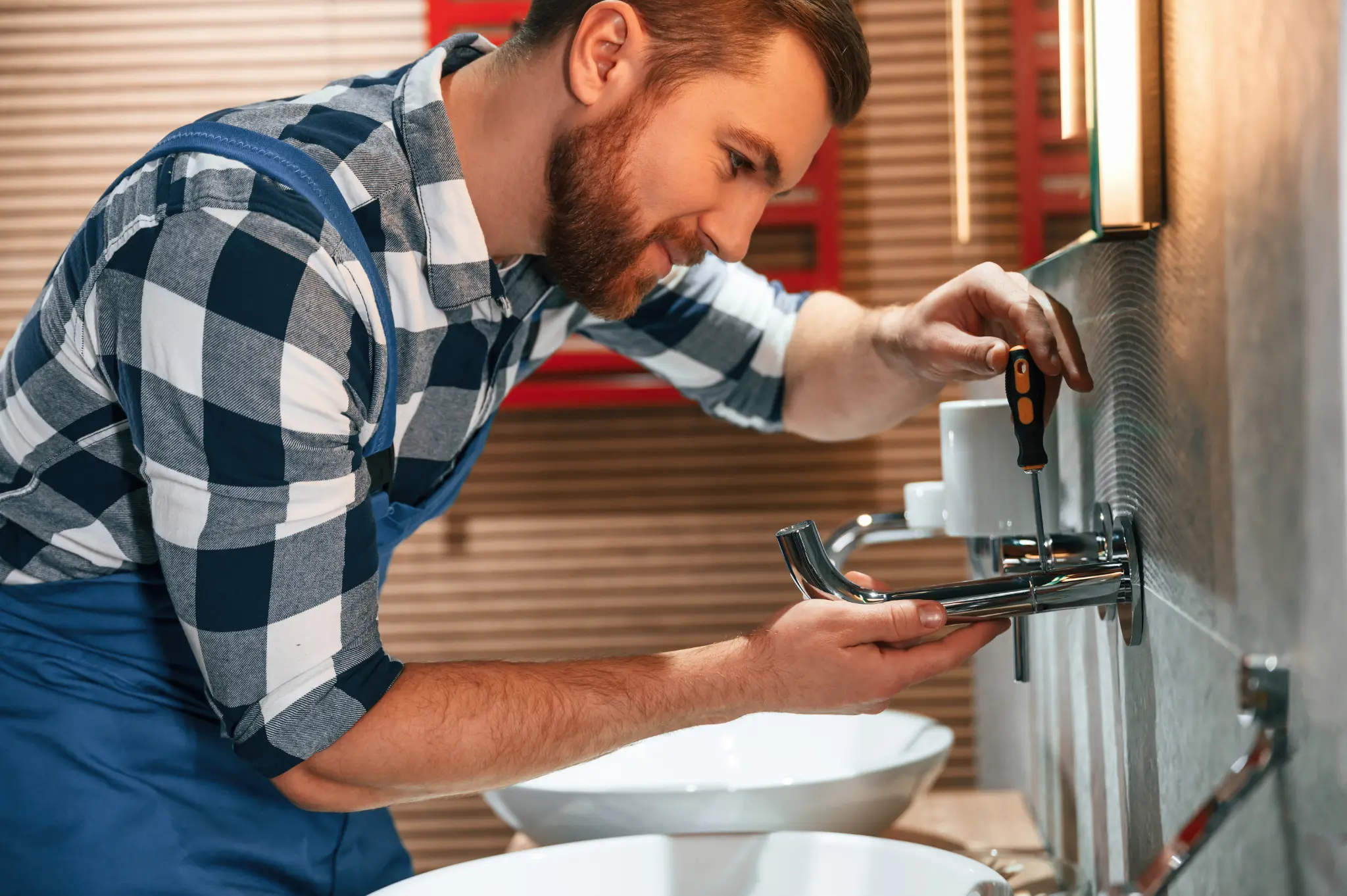 Plumber using screwdriver for faucet repairs